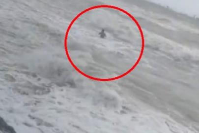 Uyarılara aldırmadı, dev dalgalara rağmen denize girdi